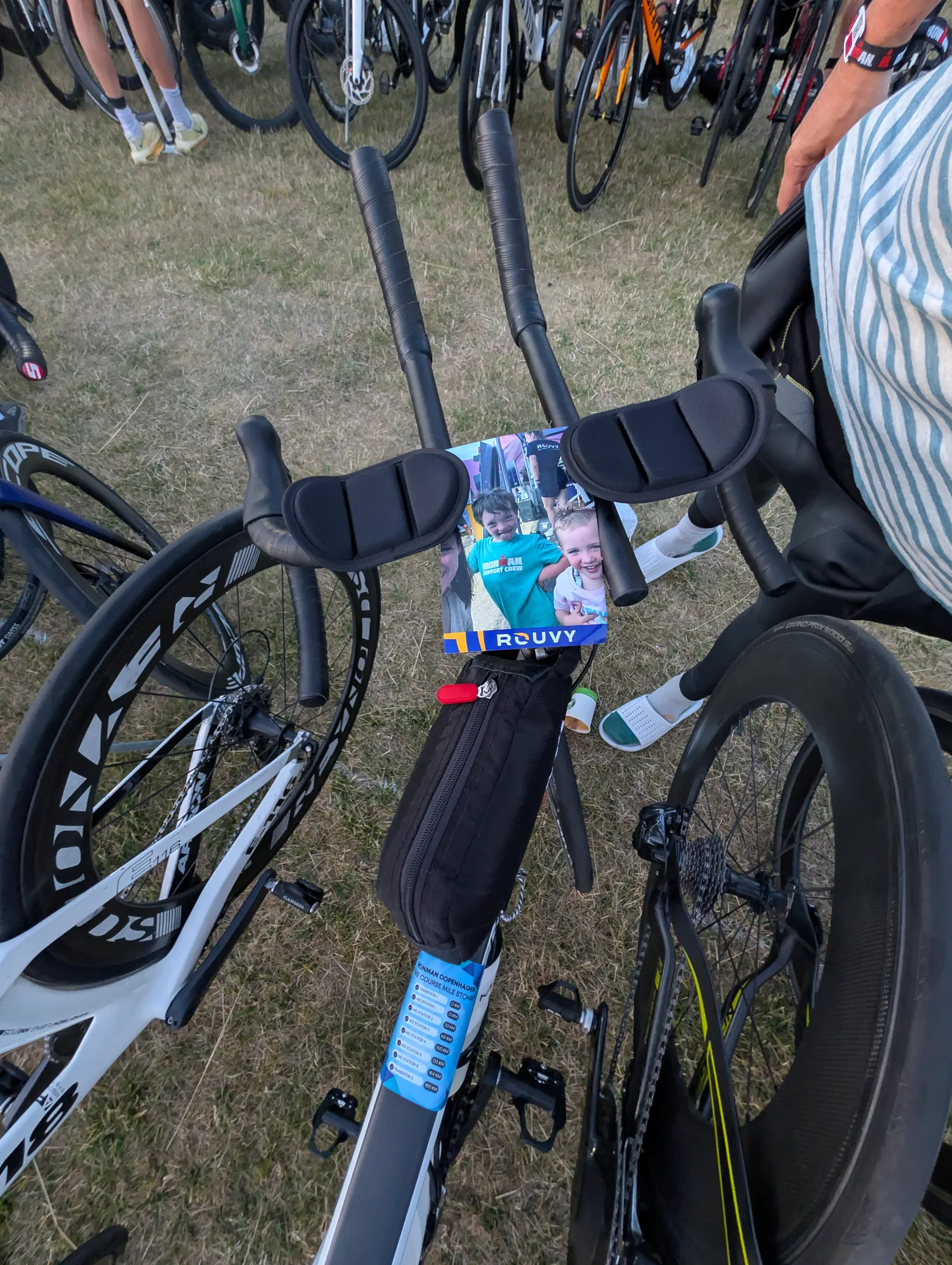 A race bike in transition with a photo of two smiling children tucked between its aero bars