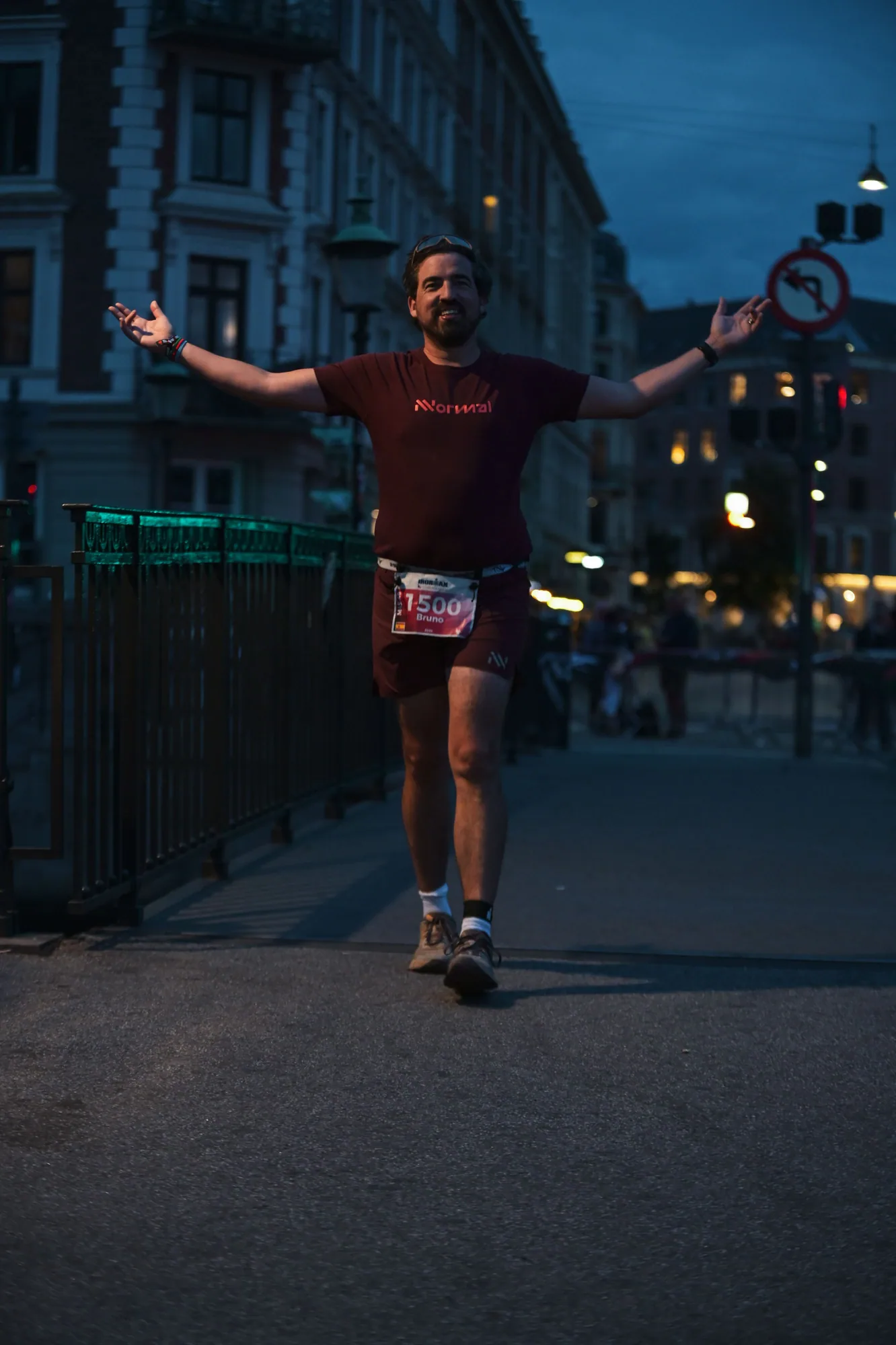 Bruno running with his arms spread on a Copenhagen street after dark